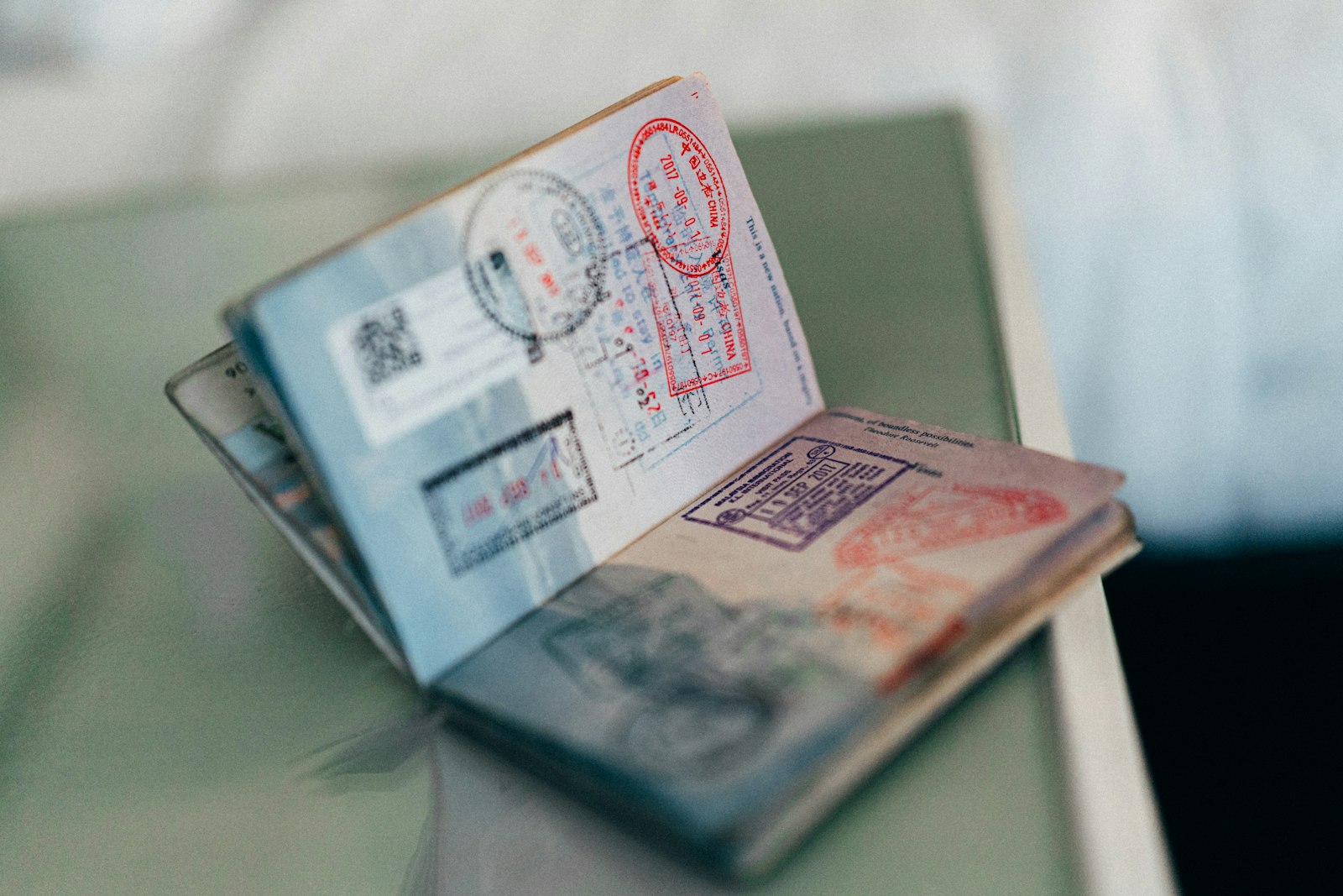 Открытый паспорт со множеством цветных штампов