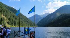 Люди с казахстанскими флагами на берегу Кольсайского озера