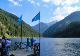Люди с казахстанскими флагами на берегу Кольсайского озера